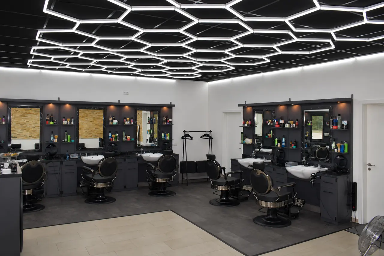Innenraum des JM Salon mit Hexagon-Deckenlicht und Barber-Stühlen